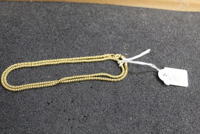 a close up of a gold chain with a tag on it