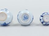 three blue and white vases sitting next to each other on a white surface