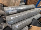 several rolls of metal mesh are stacked on top of each other in a warehouse