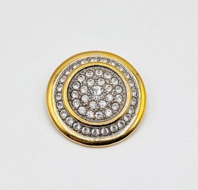 a close up of a gold and diamond button on a white background