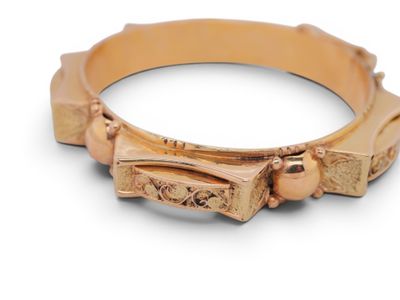 a close up of a gold ring with a bow on it