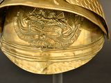 a gold helmet with a bird on it on a stand
