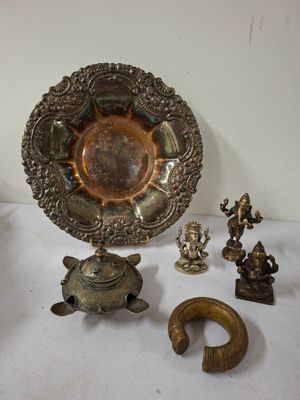 une assiette en argent et d'autres objets en métal posés sur une table