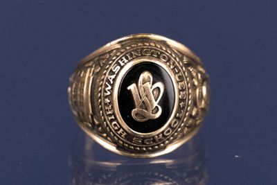 un gros plan d'une bague en or ornée d'une pierre noire au centre