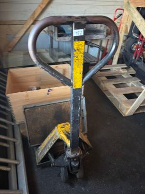 une fourche posée sur une palette dans un garage