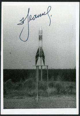 a black and white photo of a rocket sitting on top of a stand