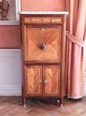 une armoire en bois avec un plateau en marbre, placée dans un coin de la pièce