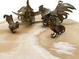 trois figurines d'animaux posées sur une table, sur fond blanc
