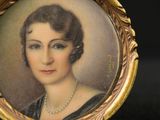 an antique portrait of a woman in a black dress and pearls