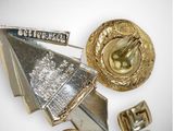 a silver and gold brooch and some other items on a table