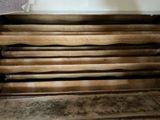 a pile of wood sitting on the floor next to a wall