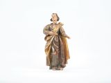 une statue représentant une femme tenant une croix, posée sur une surface blanche