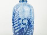 a blue and white vase sitting on a white surface