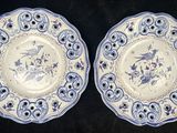 two blue and white plates with birds and flowers on them