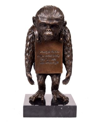statue en bronze représentant un gorille tenant une pancarte, posée sur un socle en marbre