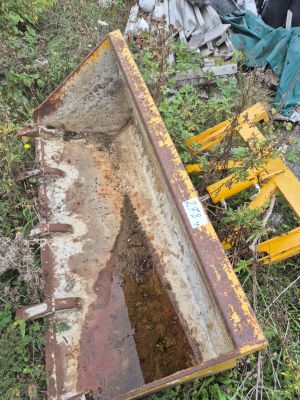 un bulldozer jaune posé par terre à côté d'un tas d'ordures