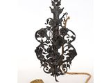 an ornate iron lamp with a rope and a tassel