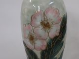 a vase with flowers painted on it sitting on a table
