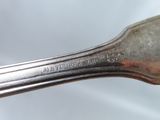 a silver spoon with a silver handle on a white surface