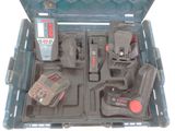 une boîte à outils contenant des outils, posée sur une surface blanche