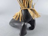 an image of a black vase with a straw hat on top of it