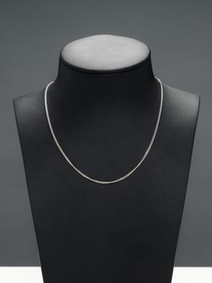 a black mannequin with a silver chain on it