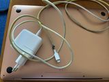 a laptop with a charger attached to it on a table