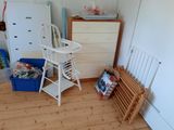 a baby high chair and a dresser in a room