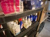 de nombreuses bouteilles de produits d'entretien sur une étagère dans une pièce