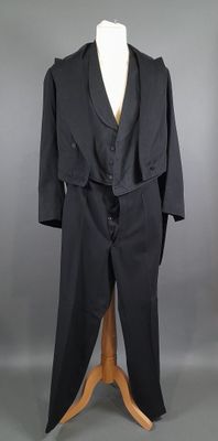 une photo d'un mannequin vêtu d'un costume noir et d'une cravate
