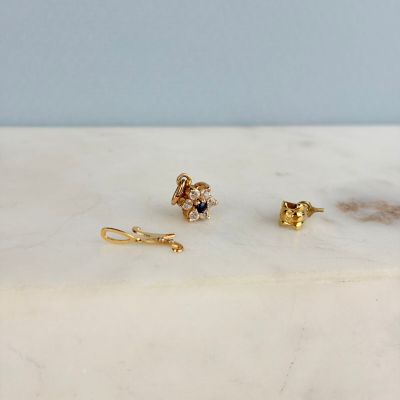 un gros plan sur une paire de boucles d'oreilles posées sur une surface en marbre