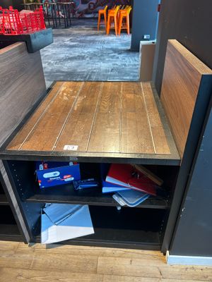 a small table with a book shelf in the corner of the room
