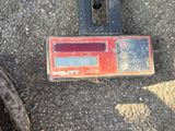 a red and black object on the ground next to a pair of black shoes
