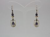 a pair of silver earrings with blue stones on them
