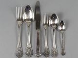 four spoons, a fork, and a knife on a table