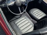 une photo d'une voiture rouge avec des sièges en cuir noir