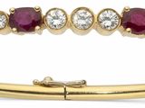 un gros plan d'une bague en or jaune sertie de rubis et de diamants