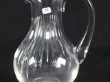 a glass pitcher with a handle on a black background