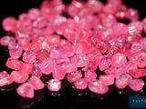 quelques diamants roses sont parsemés sur une surface noire
