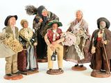 five figurines of people dressed in traditional clothing