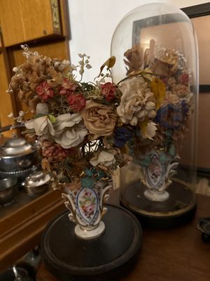 two vases that have flowers in them on a table