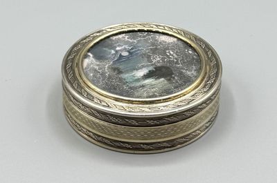 un gros plan d'une bague en argent et en or, ornée d'une pierre bleue au centre