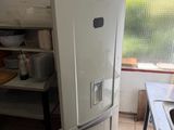a white refrigerator in a kitchen next to a window