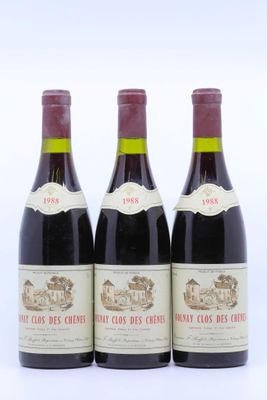 trois bouteilles de vin rouge posées l'une à côté de l'autre sur une surface blanche