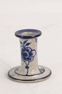 a blue and white vase with a flower on it