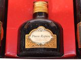 three bottles of liquor sitting in a red box on a table