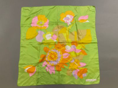 a close up of a green scarf with flowers on it