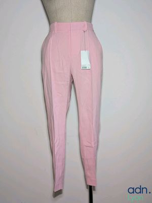 un pantalon rose sur un présentoir à mannequin, muni d'une étiquette