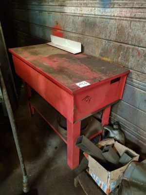 une table rouge sur laquelle se trouve une boîte, dans une pièce