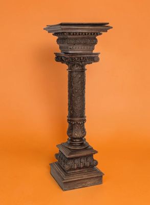 un socle ancien en fonte se détache sur un fond orange
